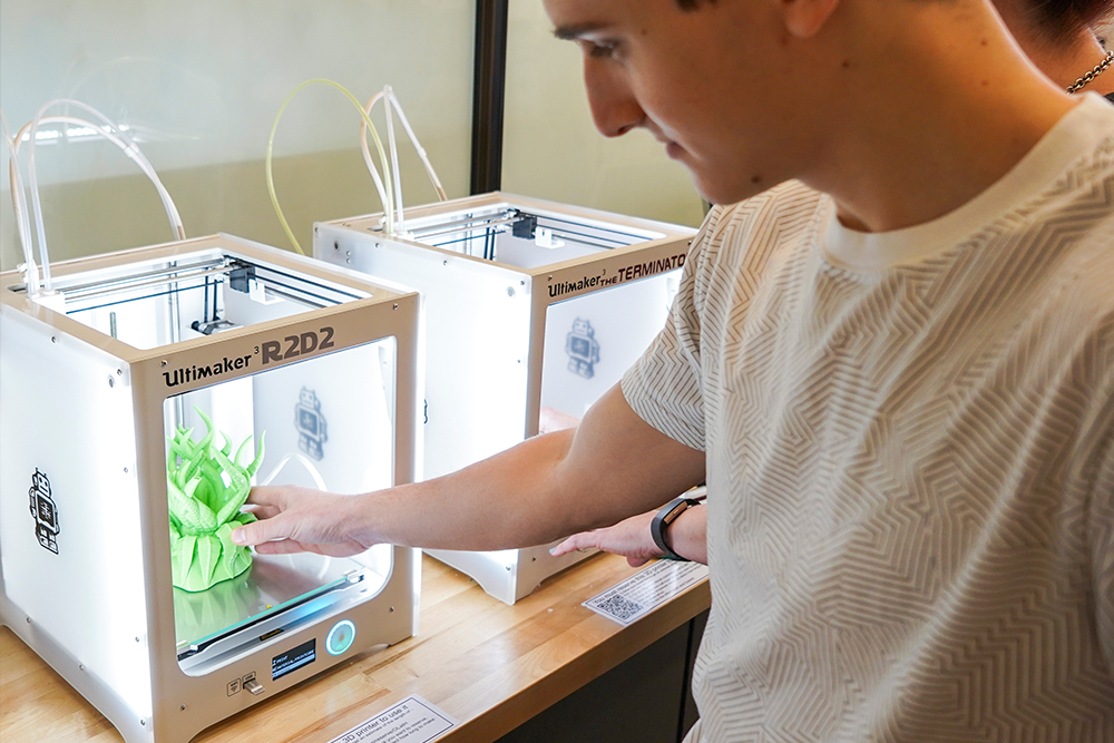 Student removing a finished 3D printed object from the 3D printer