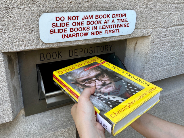 Close-up of someone using Hillman Library's bookdrop