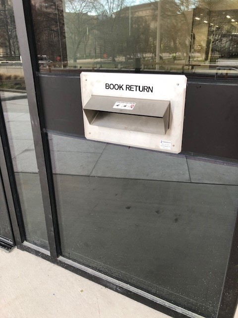 Close-up of someone using Hillman Library's bookdrop