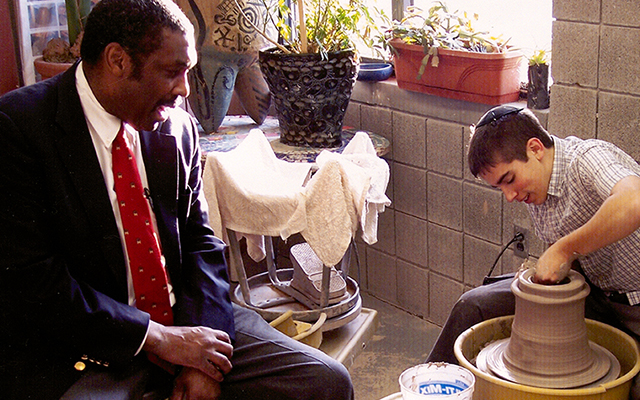 Strickland with a student who is making pottery at the Manchester Craftsmen’s Guild