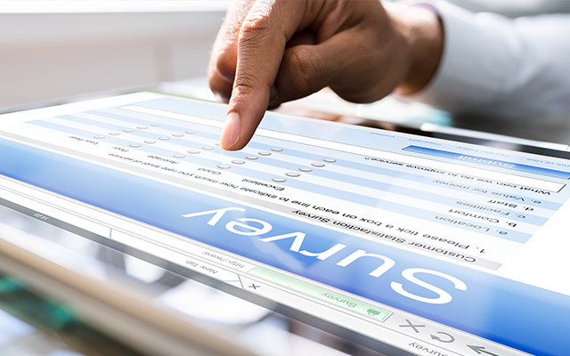 A person completing an online survey on a tablet.