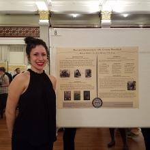 Melissa Pallotti standing next to poster